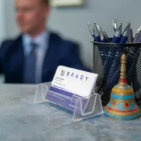 Business cards on a desk with worker behind